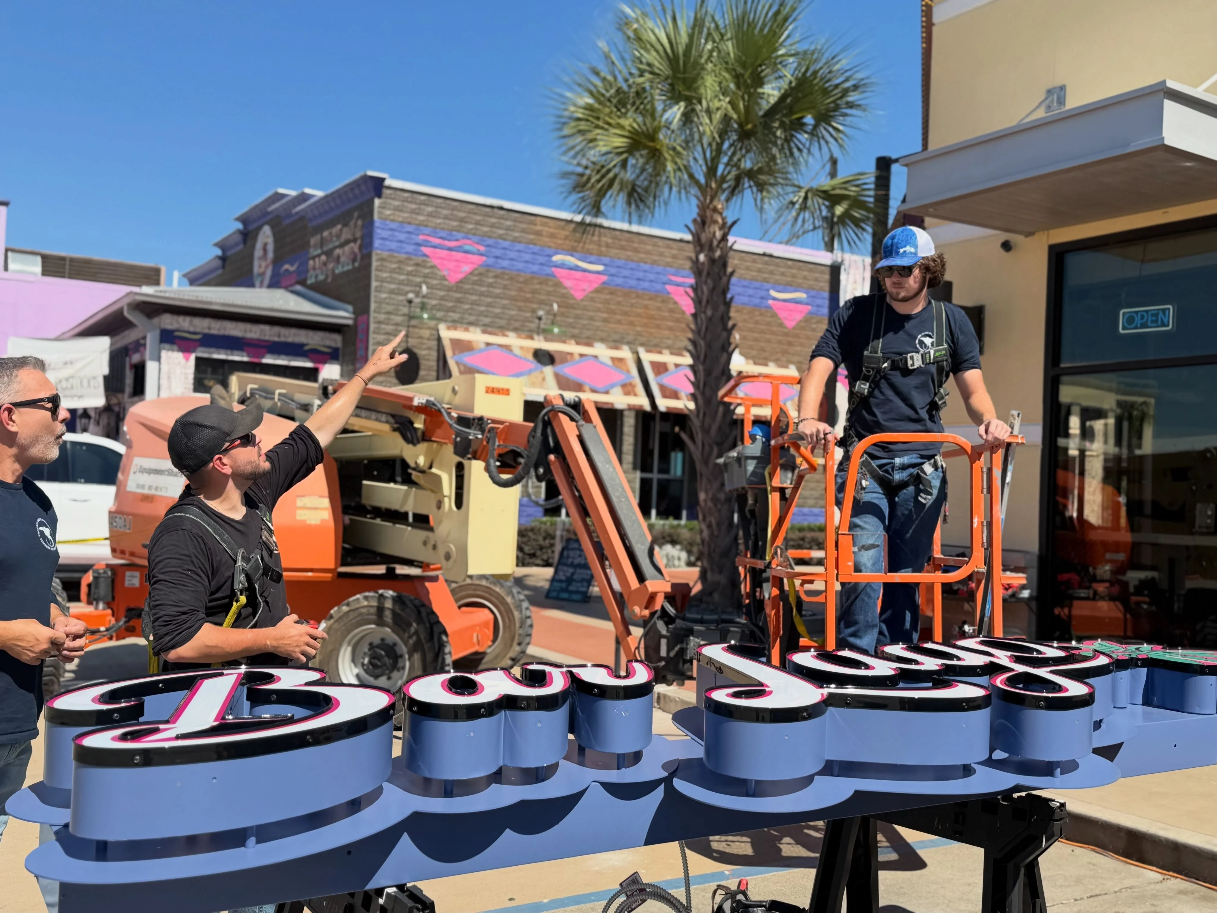 Stingray Signs LLC team prepping custom illuminated channel letters with boom lift